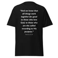 Unisex black t-shirt with Romans 8:28 Bible verse printed in white text on front