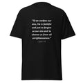 Unisex black t-shirt with 1 John 1:9 Bible verse printed in white text on front