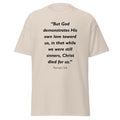 Unisex heather gray t-shirt with Romans 5:8 Bible verse printed in black text on front