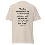 Unisex heather gray t-shirt with Romans 5:8 Bible verse printed in black text on front
