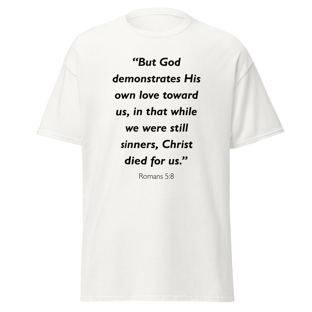 Unisex navy blue t-shirt with Romans 5:8 Bible verse printed in black text on front