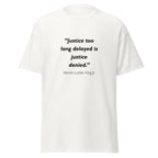 Unisex black t-shirt featuring Martin Luther King MLK Justice Delayed quote typography printed across the front chest
