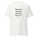 Unisex black t-shirt featuring Bill Moyers Democracy quote typography printed across the front chest