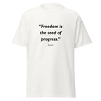Unisex black t-shirt featuring Freedom Seed Progress quote typography printed across the front chest