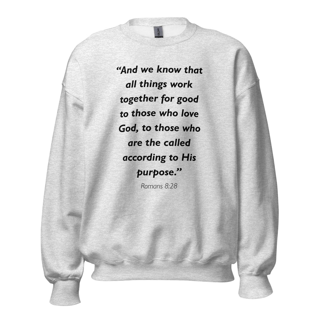 Unisex black sweatshirt with Romans 8:28 Bible verse printed in black text on front