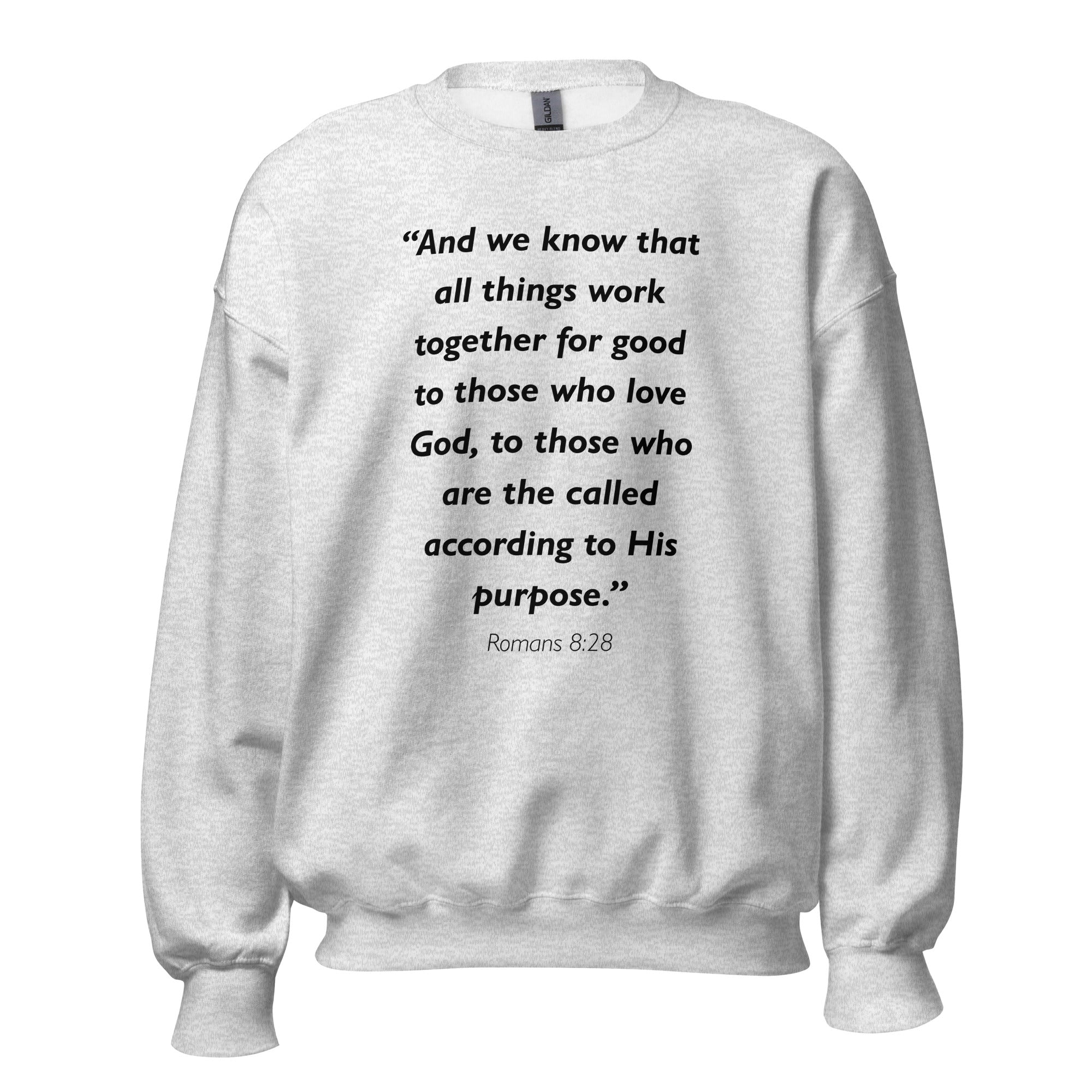 Unisex black sweatshirt with Romans 8:28 Bible verse printed in black text on front