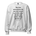 Unisex heather gray sweatshirt with Romans 5:8 Bible verse printed in black text on front