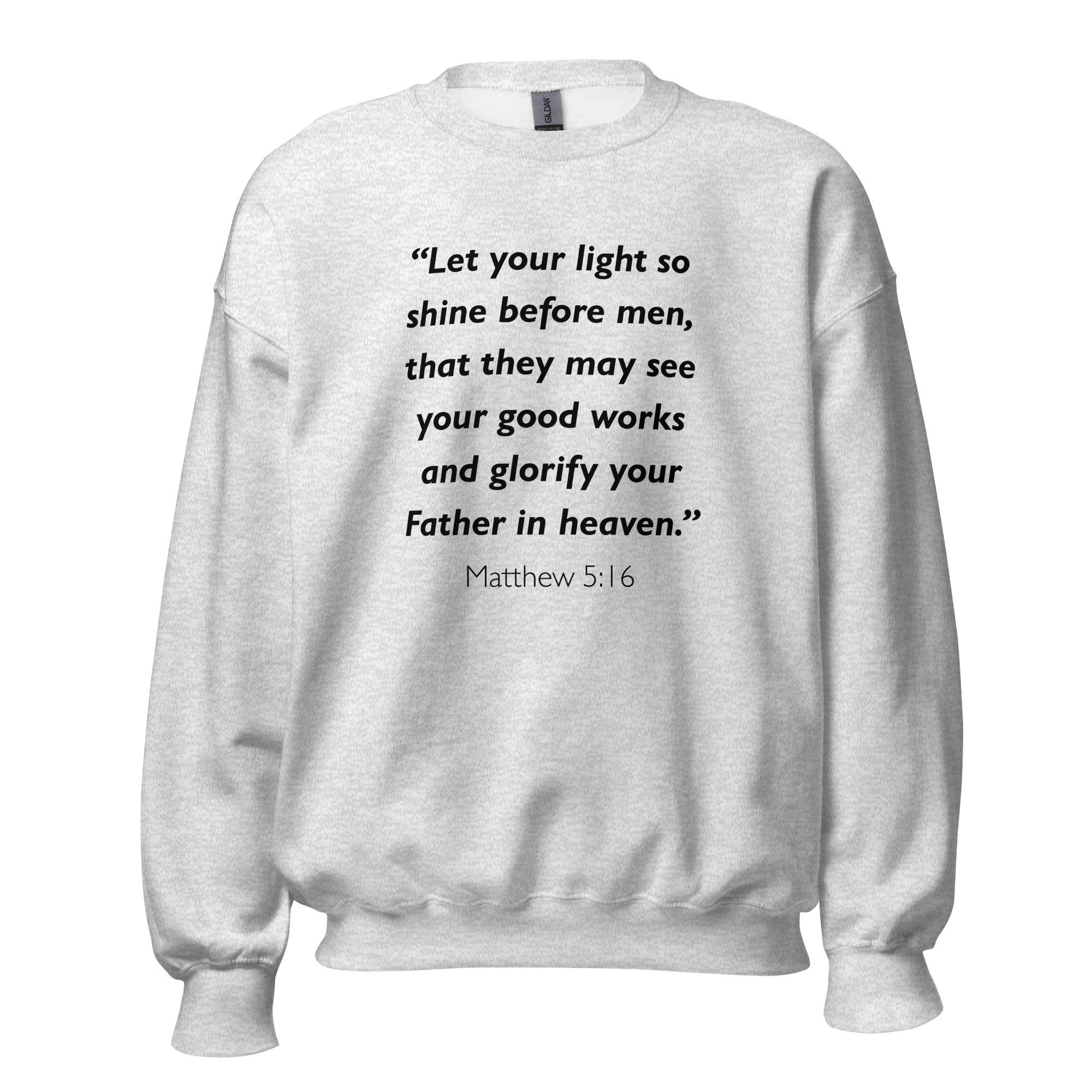 Unisex black sweatshirt with Matthew 5:16 Bible verse printed in black text on front