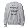 Unisex black sweatshirt with Romans 5:8 Bible verse printed in black text on front