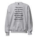 Unisex black sweatshirt with Psalm 34:18 Bible verse printed in black text on front