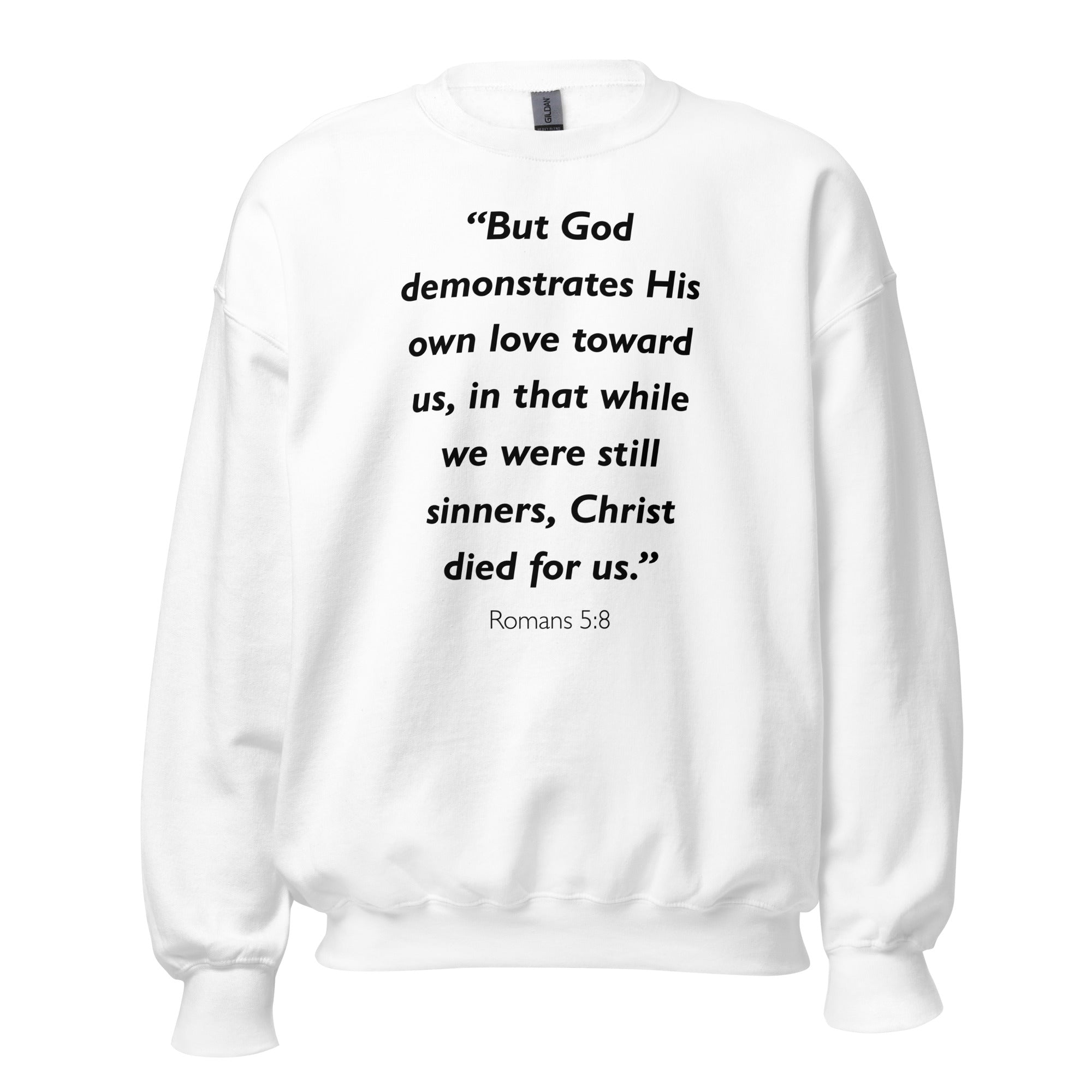 Unisex navy blue sweatshirt with Romans 5:8 Bible verse printed in black text on front