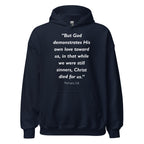 Unisex navy blue hoodie with Romans 5:8 Bible verse printed in white text on front