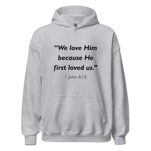 Unisex black hoodie with 1 John 4:19 Bible verse printed in black text on front